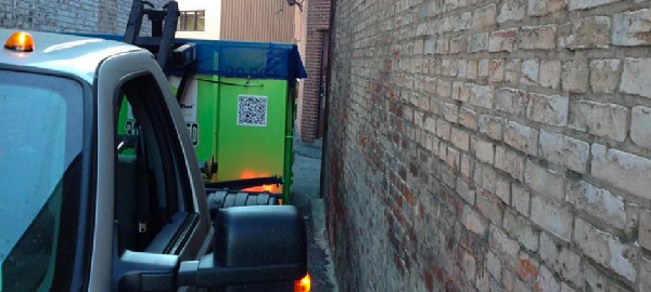Dumpster and Truck Fitting Down Narrow Alley